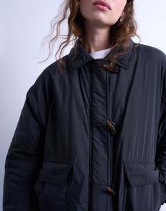 Model wearing Padded hybrid toggle bomber in black