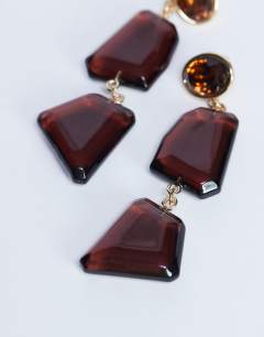 Model wearing Paige abstract drop earrings in burgundy