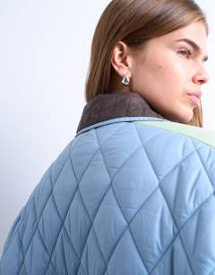 Model wearing Patchwork quilted shacket with contrast piping in blue