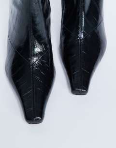 Model wearing Pearl point toe ankle boot in black eel