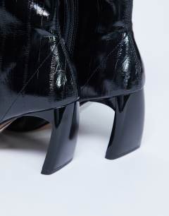Model wearing Pearl point toe ankle boot in black eel
