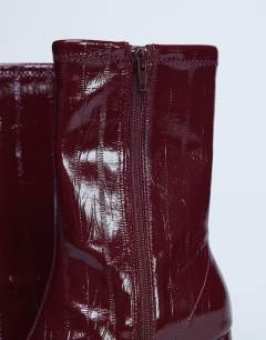 Model wearing Pearl point toe ankle boot in burgundy eel