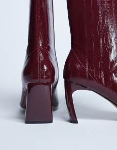 Model wearing Pearl point toe ankle boot in burgundy eel
