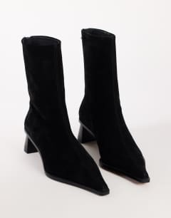 Model wearing Penny real suede block heel pointed ankle boot in black
