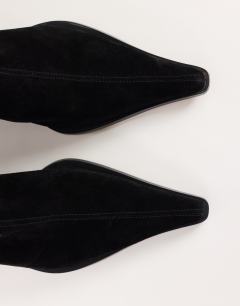Model wearing Penny real suede block heel pointed ankle boot in black