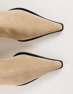 Model wearing Penny real suede block heel pointed ankle boot in taupe