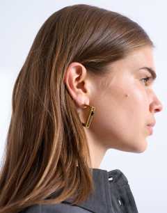 Model wearing Perry waterproof stainless steel square hoop earring in gold & black stone