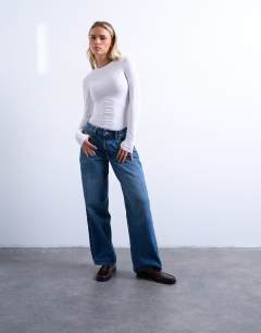 Model wearing Petite Cinch low rise relaxed jean in mid blue