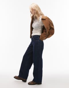 Model wearing Petite Cinch low rise relaxed jean in raw look indigo