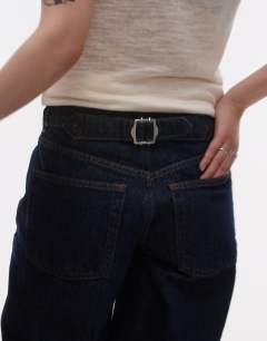 Model wearing Petite Cinch low rise relaxed jean in raw look indigo