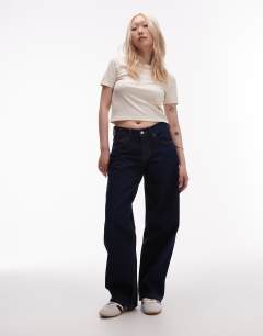 Model wearing Petite Cinch low rise relaxed jean in raw look indigo 