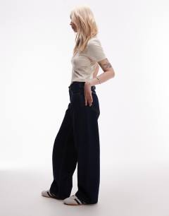 Model wearing Petite Cinch low rise relaxed jean in raw look indigo 