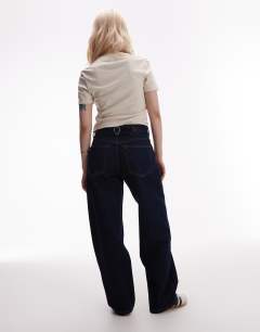 Model wearing Petite Cinch low rise relaxed jean in raw look indigo 
