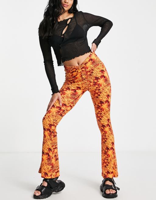 Topshop Petite knot twist front flared trouser in orange hibiscus print