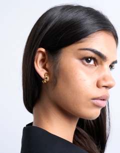 Model wearing Piper stainless steel hoop earrings with stones in gold & tiger