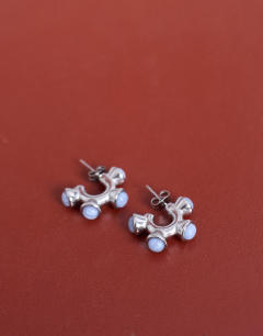 Model wearing Piper stainless steel hoop earrings with stones in silver & blue