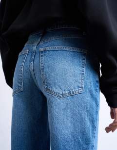 Model wearing Pippa mid rise comfort stretch flare jean in mid blue