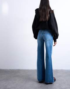 Model wearing Pippa mid rise comfort stretch flare jean in mid blue