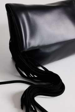 Model wearing Pippa oversized fringe clutch bag in black