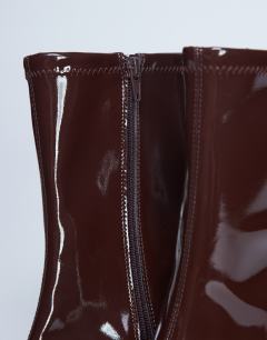 Model wearing Pippa point toe stretch ankle boot in patent chocolate