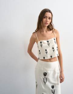 Model wearing Placement embroidery satin cami in cream