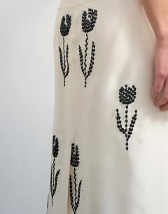 Model wearing Placement embroidery satin midi skirt in ecru