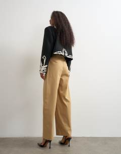 Model wearing Pleat barrel trouser in beige