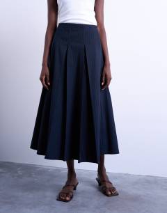 Model wearing Pleated midi skirt in navy with rust stripe