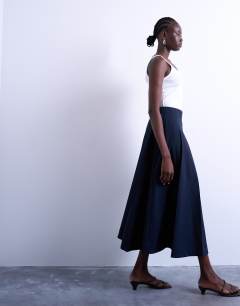 Model wearing Pleated midi skirt in navy with rust stripe