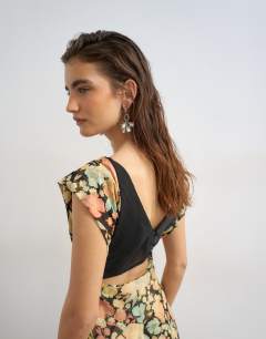 Model wearing Pleated open back maxi dress in pink and green floral