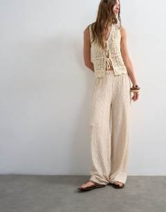 Model wearing Plisse jersey straight leg trousers in stone