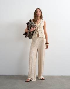 Model wearing Plisse jersey straight leg trousers in stone