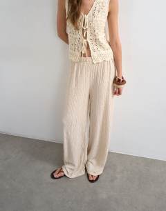 Model wearing Plisse jersey straight leg trousers in stone