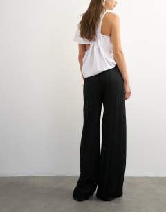 Model wearing Plisse jersey wide leg trouser in black