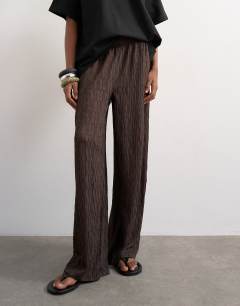 Model wearing Plisse jersey wide leg trousers in chocolate