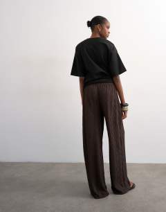 Model wearing Plisse jersey wide leg trousers in chocolate