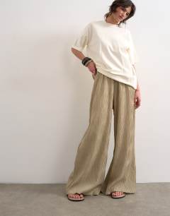 Model wearing Plisse wide leg trouser in beige