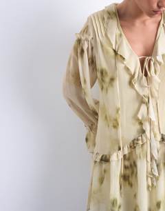 Model wearing Poet sleeve frill mini dress in green floral print