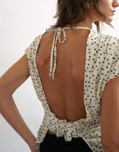 Model wearing Polka dot drape back top in cream