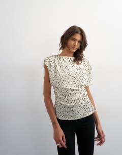 Model wearing Polka dot drape back top in cream