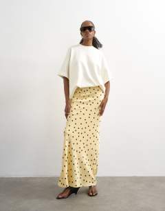 Model wearing Polka dot flood length satin bias maxi skirt in buttermilk
