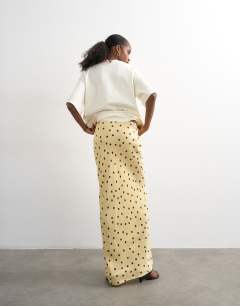 Model wearing Polka dot flood length satin bias maxi skirt in buttermilk