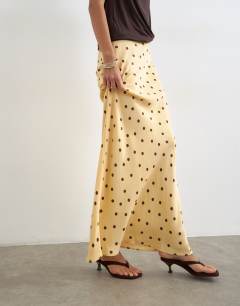 Model wearing Polka dot flood length satin bias maxi skirt in buttermilk