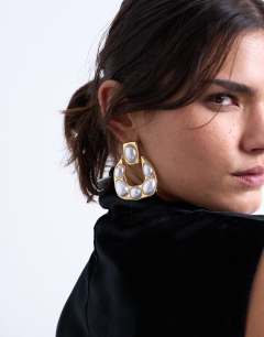 Model wearing Porter pearl stud statement earrings in gold