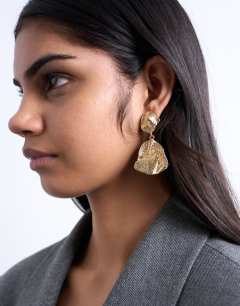 Model wearing Portia drop earrings in gold
