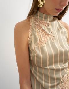 Model wearing Premium halter neck top with contrast lace detail in green stripe