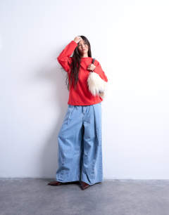 Model wearing Premium interlock long sleeve skater tee in red