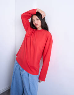 Model wearing Premium interlock long sleeve skater tee in red