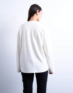 Model wearing Premium interlock long sleeve skater tee in white