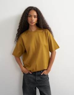 Model wearing Premium interlock t-shirt in ochre